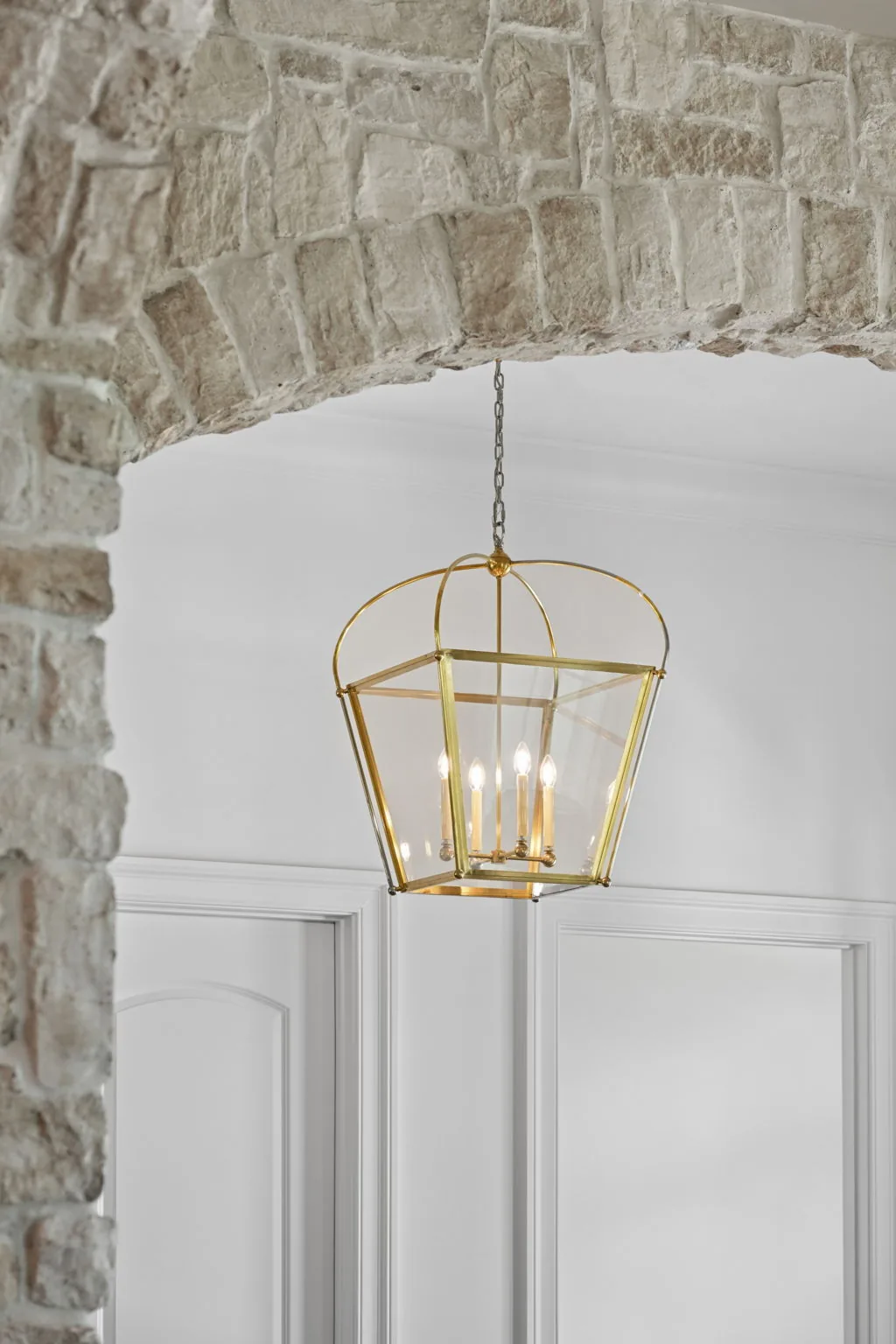 Stone archway with a brass lantern in a new home